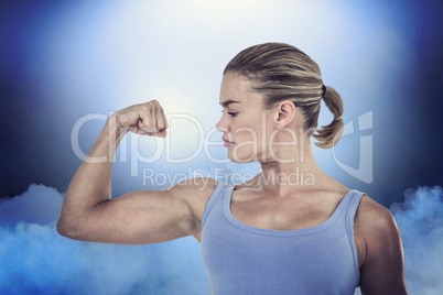 Composite image of muscular woman flexing her muscle