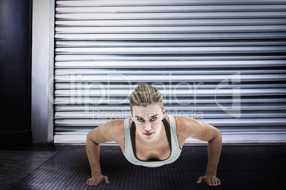 Composite image of muscular woman doing push-ups