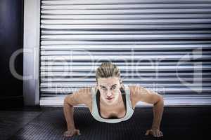 Composite image of muscular woman doing push-ups