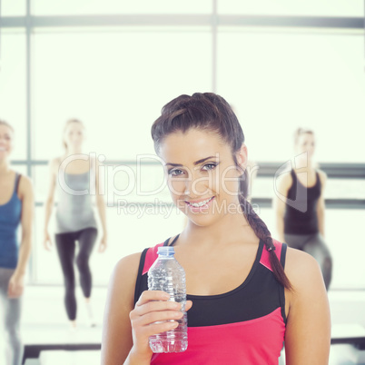 Composite image of fit woman holding water bottle