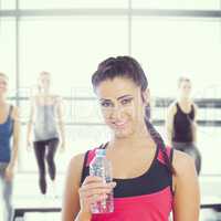 Composite image of fit woman holding water bottle