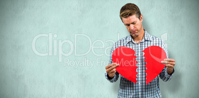 Composite image of sad man holding a broken card