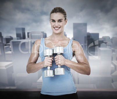 Composite image of muscular woman exercising with dumbbells