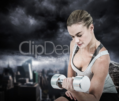 Composite image of  muscular woman working out with dumbbells