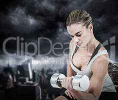 Composite image of  muscular woman working out with dumbbells