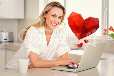 Composite image of happy woman using laptop at counter