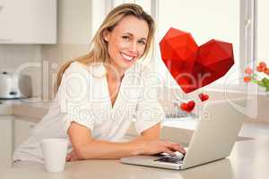 Composite image of happy woman using laptop at counter