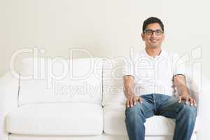 Lonely single Asian man sitting on couch