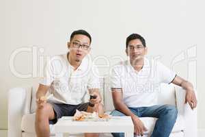 Men friends watching sport match on tv