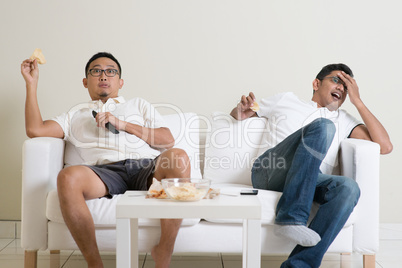 Men watching sport game on tv at home