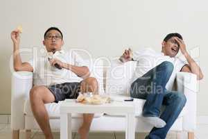 Men watching sport game on tv at home