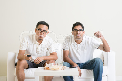 Men watching football game on tv at home