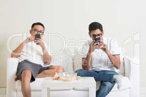 Bored friends playing own smartphones