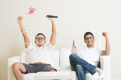 Malaysian men watching sports on tv