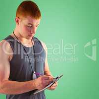 Composite image of fit personal trainer writing on clipboard