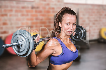 Composite image of portrait of fit woman lifting crossfit