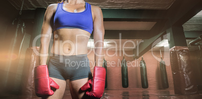 Composite image of midsection of female boxer with gloves