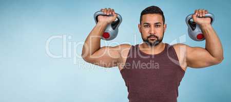 Composite image of muscular serious man lifting kettlebells