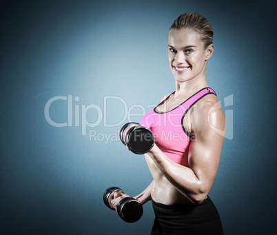 Composite image of muscular woman lifting heavy dumbbells