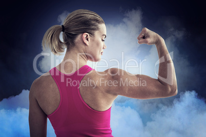 Composite image of rear view of muscular woman flexing muscles