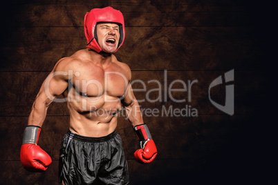 Composite image of angry boxer against black background