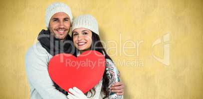 Composite image of smiling couple holding paper heart