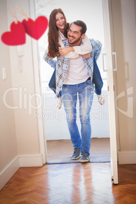 Composite image of young man giving girlfriend a piggyback ride