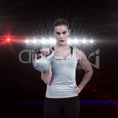 Composite image of serious muscular woman lifting kettlebell