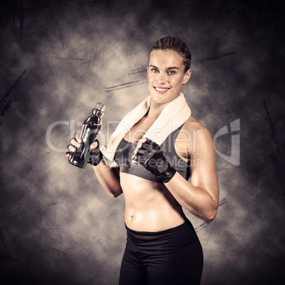 Composite image of muscular woman drinking water