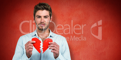 Composite image of sad man holding heart halves