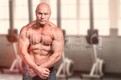 Composite image of portrait of bald man flexing muscles