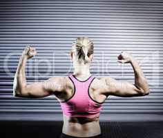 Composite image of muscular woman flexing her arms