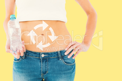 Composite image of mid section of a fit woman holding a bottle o