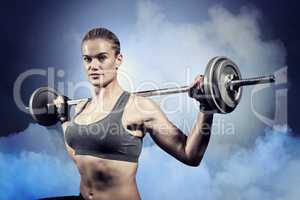 Composite image of muscular woman lifting heavy barbell
