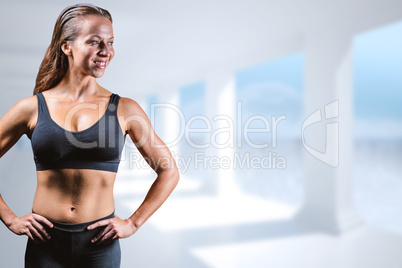 Composite image of cheerful athlete with hands on hip