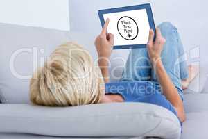 Composite image of blonde woman using her tablet on the couch