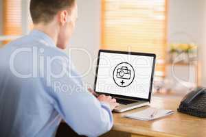 Composite image of businessman working on his laptop