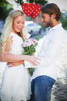 Composite image of attractive couple with bunch of flowers