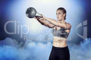 Composite image of muscular woman swinging heavy kettlebell