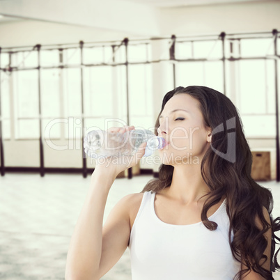 Composite image of brunette drinking water