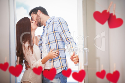 Composite image of young couple kiss as they open front door