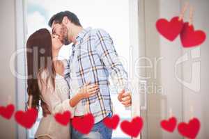 Composite image of young couple kiss as they open front door