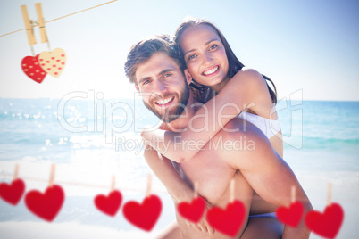 Composite image of handsome man giving piggy back to his girlfri