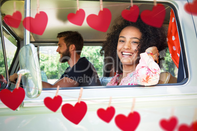 Composite image of hipster couple driving in camper van