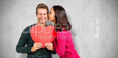 Composite image of woman kissing boyfriend with red heart shape