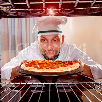 Chef cooking pizza in the oven.