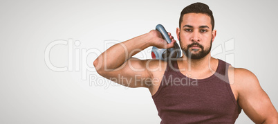 Composite image of muscular serious man holding a kettlebell Composite image of muscular serious man holding a kettlebell