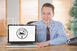 Composite image of happy businessman showing laptop screen