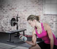 Composite image of muscular woman exercising with dumbbells