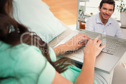 Composite image of smiling man using digital tablet at home